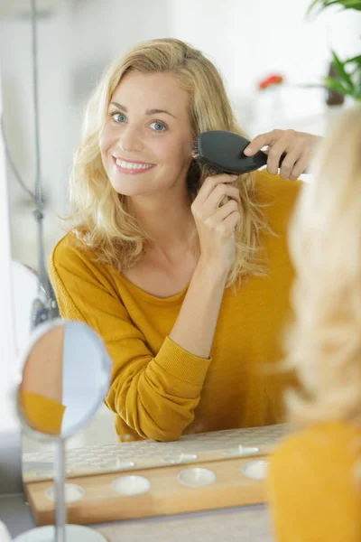 Bela Mulher Escovando Seu Cabelo Frente Espelho — Fotografia de Stock