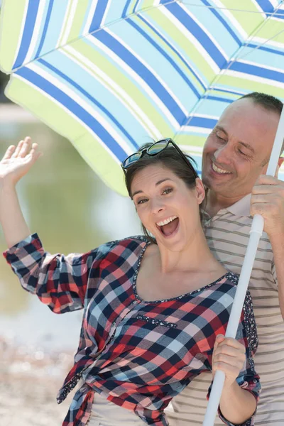 Vrolijke Ouders Ontspannen Onder Zon Paraplu — Stockfoto