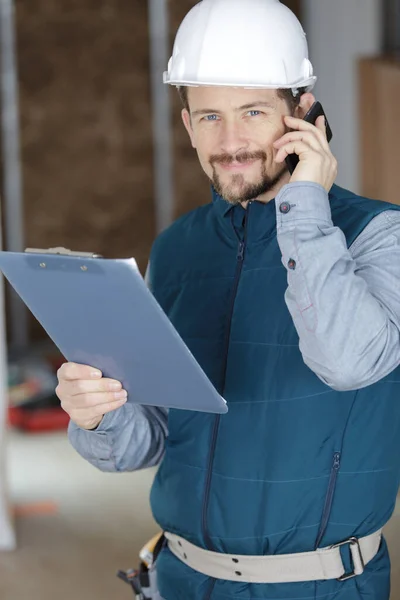 Portrait Young Handyman Holding Clipboard Indoors — Stock Photo, Image