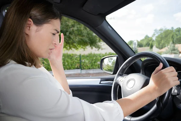 車の中で頭痛を持つ女性は ロイヤリティフリーのストック画像
