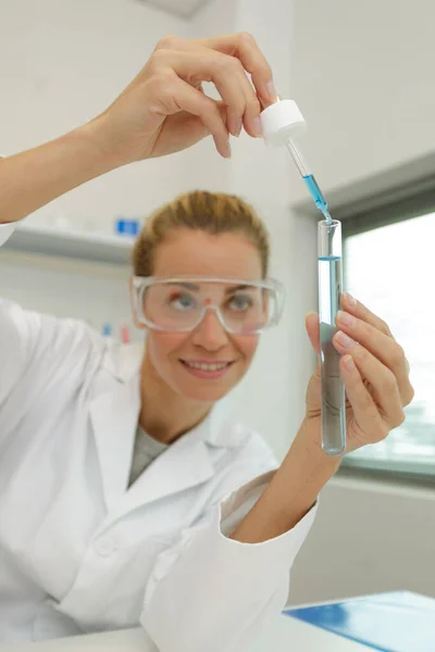 女科学家戴着安全护目镜 在实验室拿着长笛 — 图库照片
