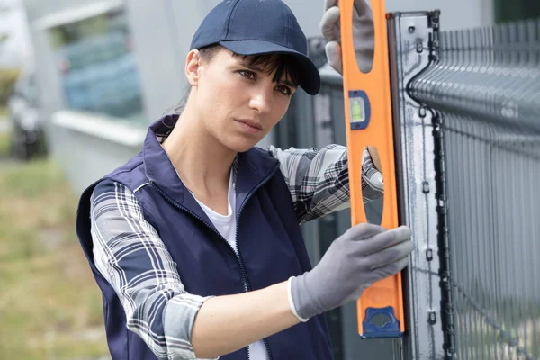 Ernsthafte Frau Überprüft Das Niveau Eines Zauns — Stockfoto