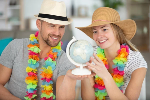 Fröhliches Paar Blickt Wohnzimmer Auf Eine Weltkugel — Stockfoto