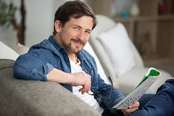 Jonge Man Zitten Doen Een Kruiswoordpuzzel — Stockfoto