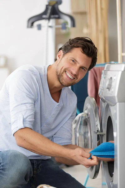Mutfaktaki Çamaşır Makinesine Çamaşır Yükleyen Mutlu Adam — Stok fotoğraf