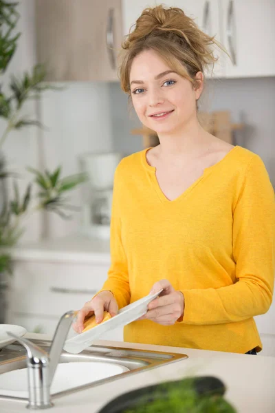 10代の少女が食器を洗い — ストック写真