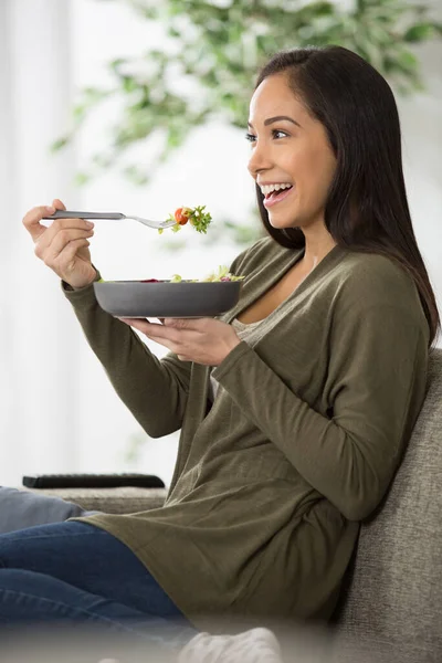 Mujer Alegre Sentada Sofá Comiendo Una Ensalada —  Fotos de Stock