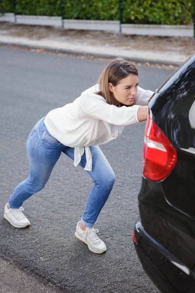 Mulher Empurrando Carro Quebrado Enquanto Seu Namorado Está Dirigindo — Fotografia de Stock