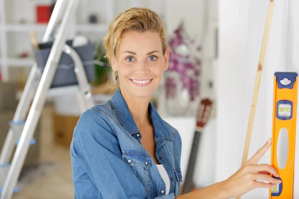 Vrouw Dragen Grijs Shirt Met Behulp Van Leveling Tool Thuis — Stockfoto