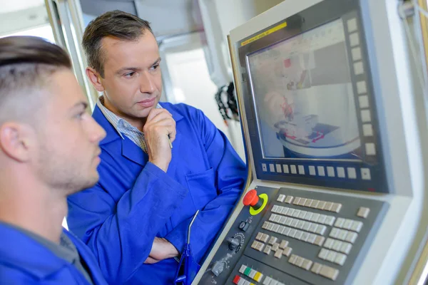 Two technicians looking at monitor