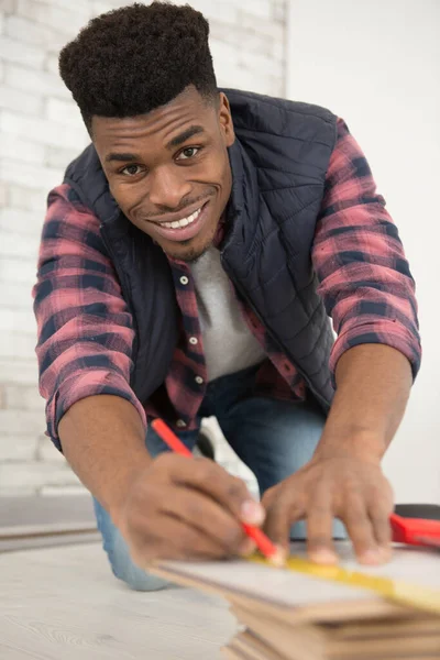 Young Man Measures Wooden Board — Stock Photo, Image