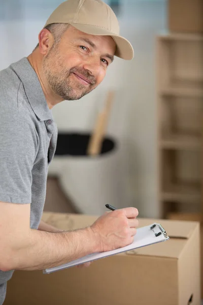 Glad Leverans Man Med Paketlåda Skriva Urklipp — Stockfoto