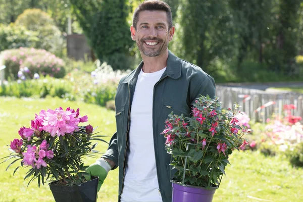 鉢植えの花を持った若い成人男性労働者の肖像画 — ストック写真