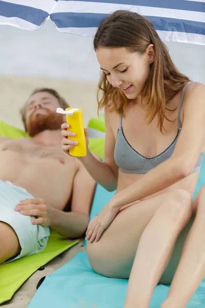 Donna Sulla Spiaggia Applicare Crema Solare — Foto Stock