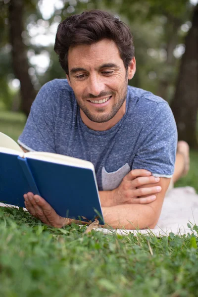 Homem Deitado Grama Relaxando Lendo Livro — Fotografia de Stock