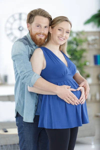 快乐的怀孕夫妇在屋里拥抱 — 图库照片