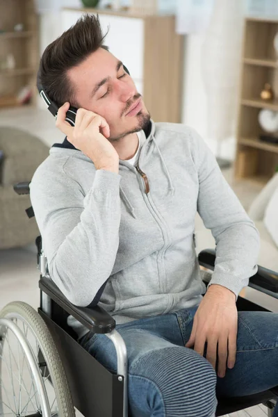 Man Wheelchair Listening Music Home — Stock Photo, Image