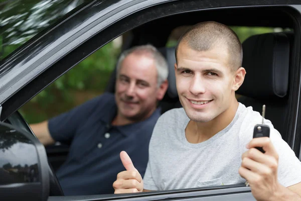 Junger Mann Lächelt Und Hält Schlüssel Der Hand — Stockfoto