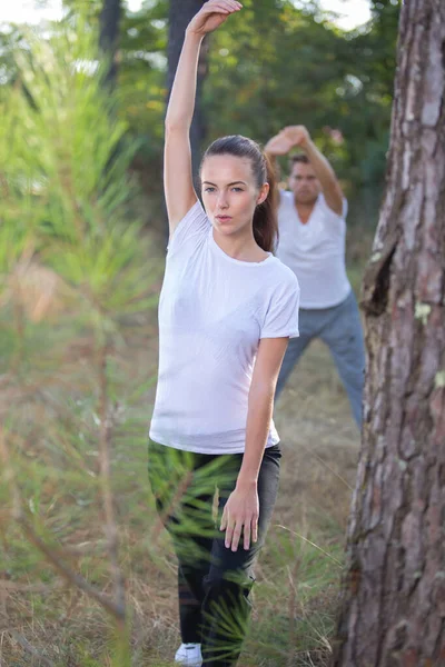 Paar Trainen Buiten Elk Een Andere Stretching Positie — Stockfoto