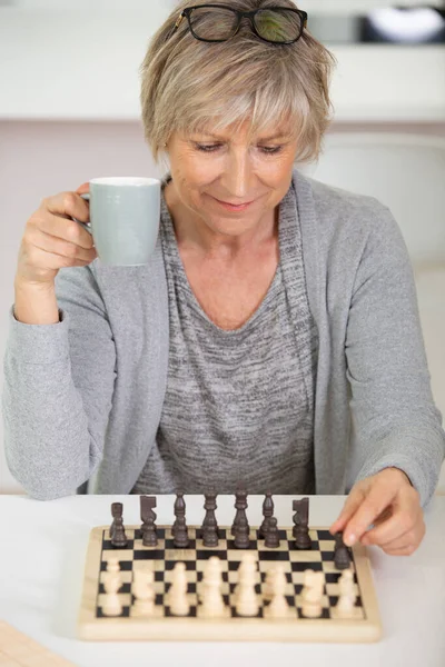 Mulher Sênior Sentada Mesa Jogando Xadrez Casa — Fotografia de Stock