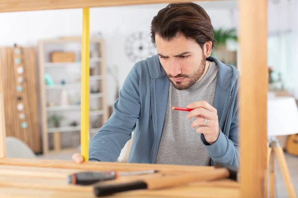 Konzentrierter Junger Mann Baut Möbel Zusammen — Stockfoto