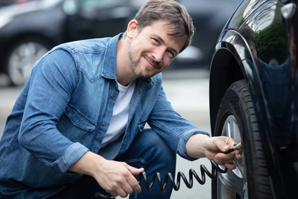 Fahrer Überprüft Luftdruck Und Füllluft — Stockfoto