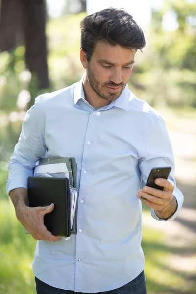 公園で携帯電話で話している若いビジネスマンの肖像画です — ストック写真