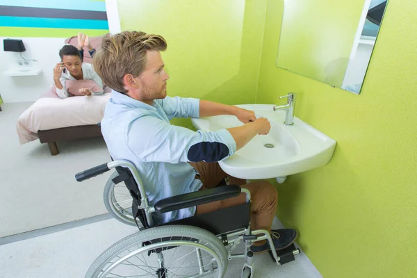 坐在轮椅上洗手的人 — 图库照片