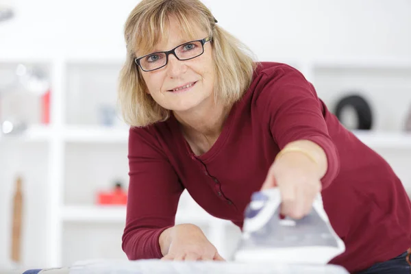 Een Oudere Vrouw Strijken Kleding — Stockfoto