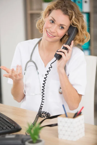 Doctor Hablando Por Teléfono Mientras Usa Portátil —  Fotos de Stock