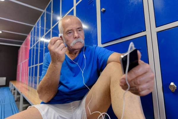 Ανώτερος Γυμναστής Βάζει Ακουστικά Του — Φωτογραφία Αρχείου