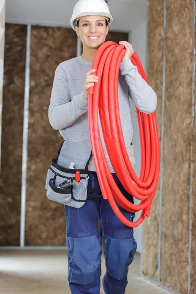 Vrouwelijke Loodgieter Draagt Rode Buizen — Stockfoto