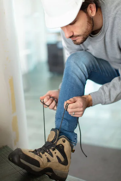 Jovem Trabalhador Amarrando Seus Bootlaces — Fotografia de Stock