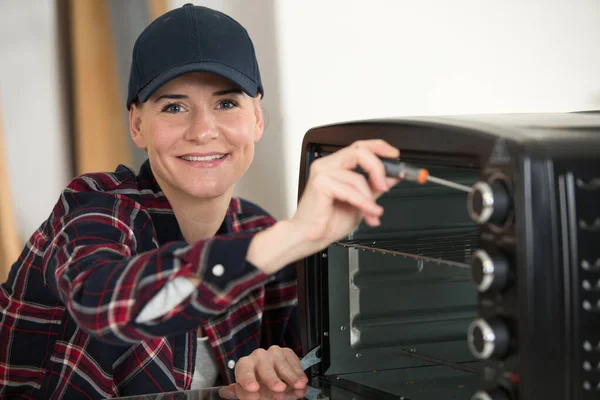 Female Electrician Fixing Oven Unit — Stock Photo, Image