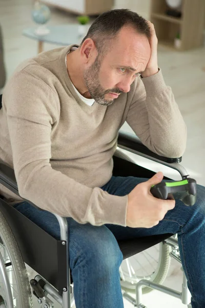 upset man in wheelchair is losing the computer game