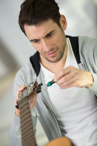 Mann Benutzt Einen Schraubenzieher Der Gitarre — Stockfoto