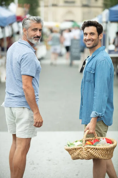 两个人在当地市场拿着柳条筐 — 图库照片