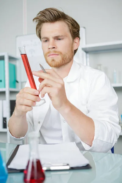 男化学家在实验室里分析血液 — 图库照片
