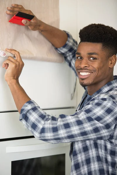 Młody Człowiek Pracuje Ścianie Domu — Zdjęcie stockowe