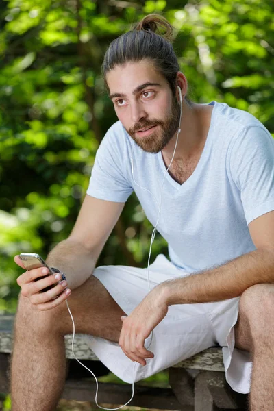 Man Die Naar Een Koptelefoon Luistert Die Aangesloten Zijn Smartphone — Stockfoto