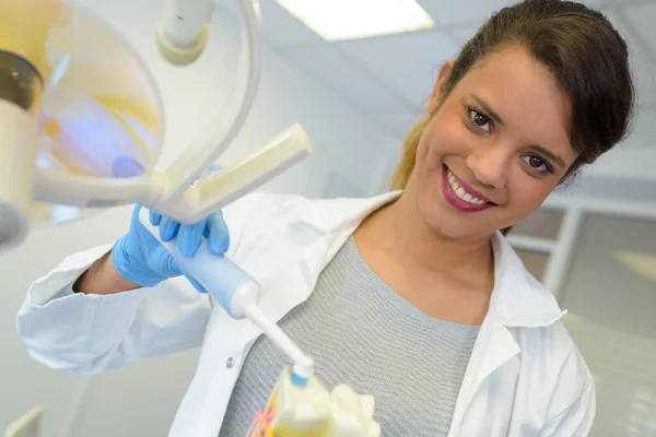 歯を磨く方法を示す若い女性歯科医は — ストック写真