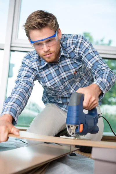 Man cutting wood board indoors — Stock Image Man Cutting Wood Board Indoors Royalty Free Stock Images