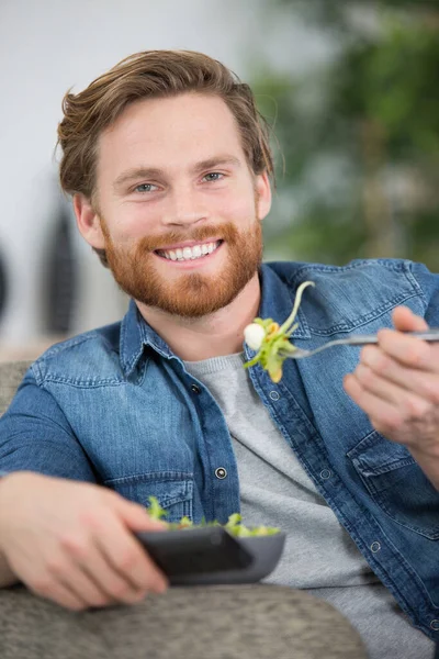 Man Die Een Salade Eet Afstandsbediening Vasthoudt — Stockfoto