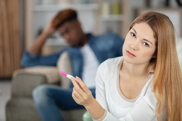 Traurige Junge Frau Hält Schwangerschaftstest Auf Dem Sofa — Stockfoto