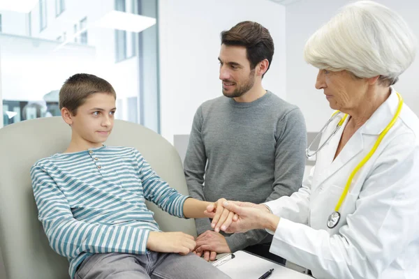 Bayan Bir Doktor Babasıyla Gelen Küçük Çocuğu Kontrol Ediyor — Stok fotoğraf