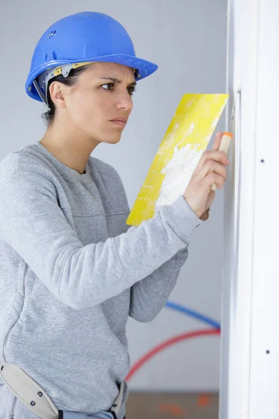 女工在房子里贴上油漆墙 — 图库照片