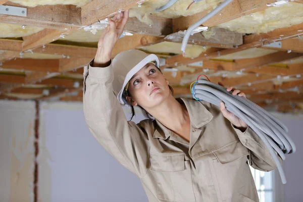 天井照明を固定する女性電気技師は — ストック写真