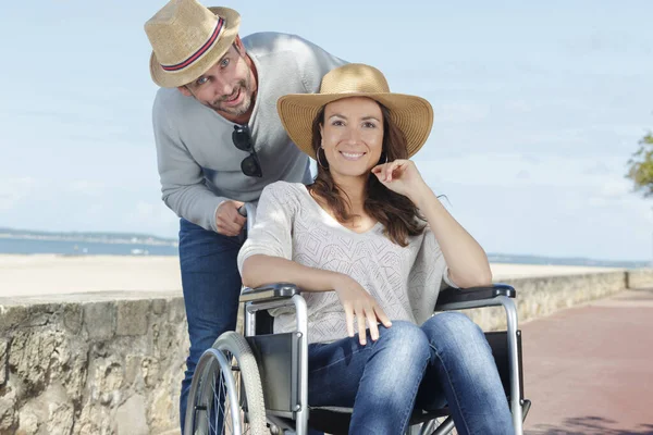 Kobieta Wózku Inwalidzkim Mężczyzna Patrząc Aparat — Zdjęcie stockowe