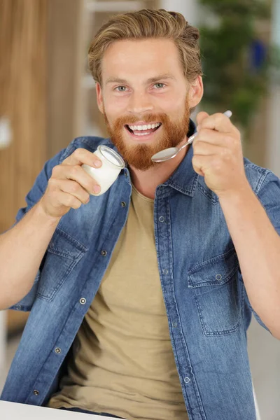 Junger Glücklicher Mann Isst Joghurt — Stockfoto