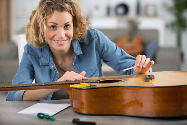 Vrouw Repareren Van Een Akoestische Gitaar — Stockfoto